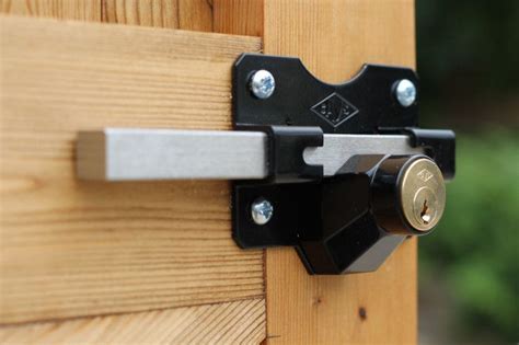 Long Throw Stainless Steel Exterior Gate Lock with a Key on one side and a stainless steel slide ...