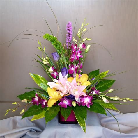 Bright and cheery arrangement with cymbidium and dendrobium orchids, lilies … | Flower ...