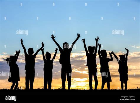 Happy kids silhouettes on sunset background Stock Photo - Alamy