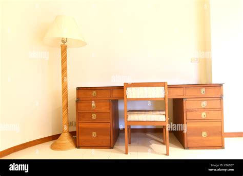 a wooden bedside table with three drawers and reading lamp Stock Photo - Alamy