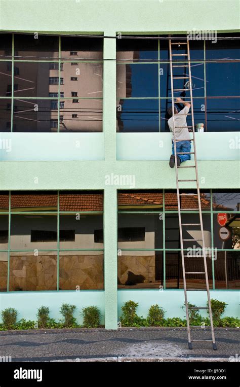 Man, painting, window, Brazil Stock Photo - Alamy