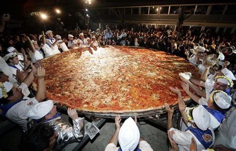 a huge pizza is being served to people