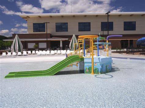 an outdoor play area in front of a building with a slide and water park ...