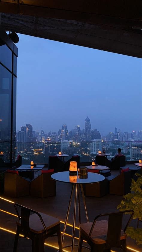 an outdoor dining area overlooking the city at night