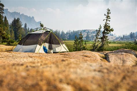 Camping Tent Pitched on a Rock Stock Photo - PixelTote