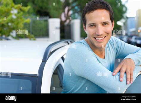 Portrait of a mid adult man leaning at open car door Stock Photo - Alamy