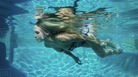 Underwater view of woman in bikini swimming in pool - Stock Photo ...