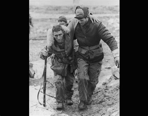 1950: A United Nations soldier in uniform helps a wounded Canadian ...