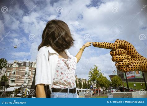 Young Woman Points the Finger the Sculpture of a Yellow Hand, in ...