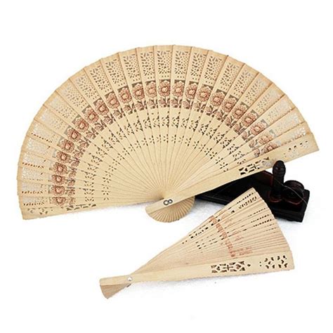 three wooden fans with carved designs on the front and sides, one fan ...