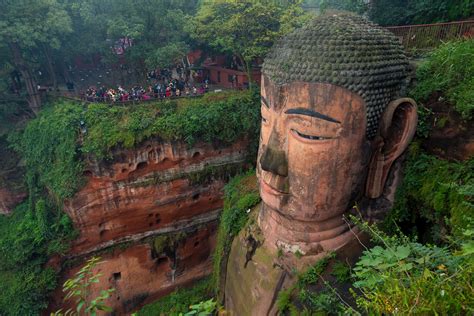 a large buddha statue sitting on top of a cliff