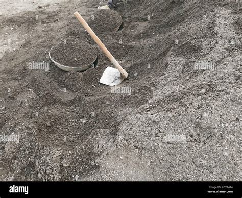 Fawda and ghamela, spade and tasla lying on heap of gravel on a construction site.A Stock Photo ...