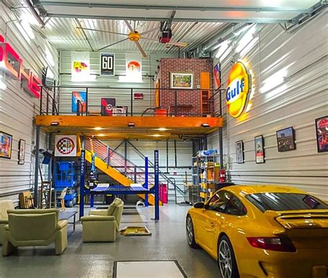 a yellow sports car is parked in a large garage with stairs to the second floor