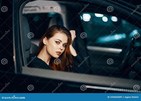 A Stylish, Luxurious Woman Sits in a Black Car at Night in the ...