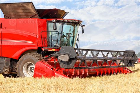 Fragment of a standing red large combine harvester for harvesting wheat on a summer day. 5433154 ...