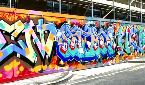 a wall covered in lots of colorful graffiti