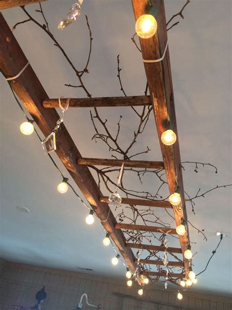 A vintage wooden ladder makes great lighting! This one is wrapped with globe lights, and ...