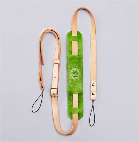 a pair of green and tan straps with an eye on them