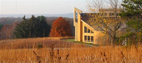 Holy Wisdom Monastery building overlooking woods and lake in distance