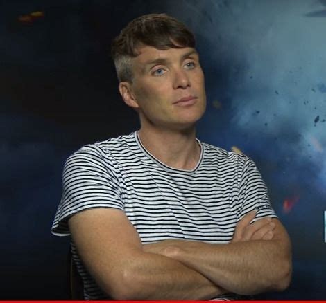 a man with his arms crossed standing in front of a blue and white ...