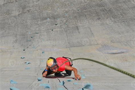 Girl climbing on artificial climbing wall of a dam 18897076 Stock Photo at Vecteezy