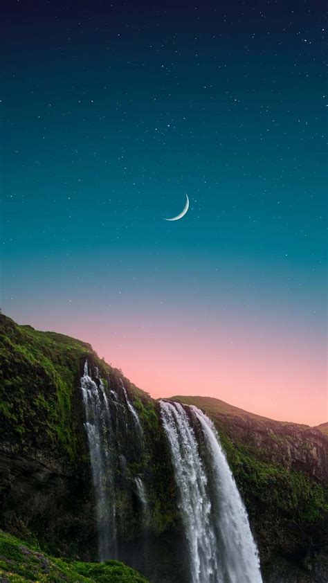 a waterfall with a crescent in the sky