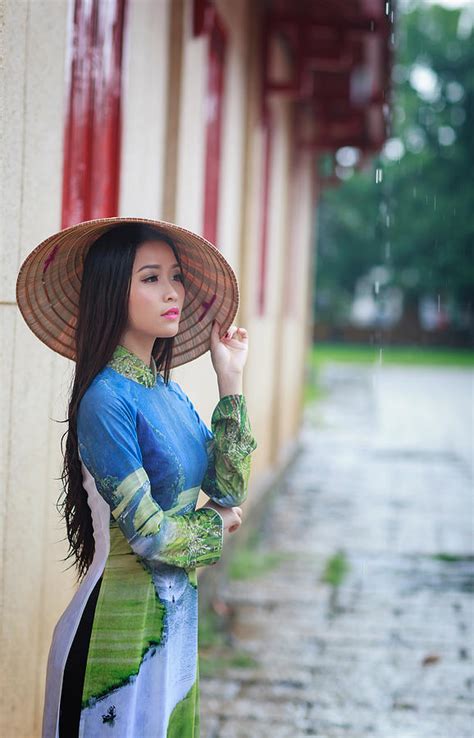 Vietnamese women wear Ao in the rain. Ao dai is famous traditional custume for woman in Vietnam ...