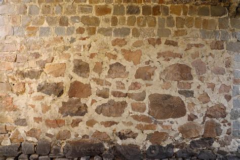 Texture of a stone wall with many big brown and grey stones armed with cement. Old castle stone ...