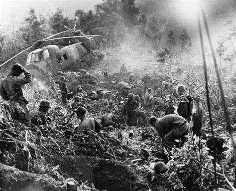 Weary after a third night of fighting against North Vietnamese troops, U.S. Marines crawl from ...