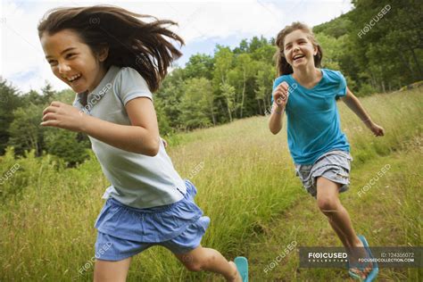 Girls running and playing chase — people, grass - Stock Photo | #124356072