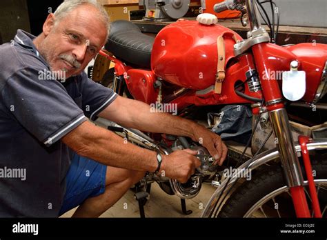 Mechanic repairs moped Stock Photo - Alamy