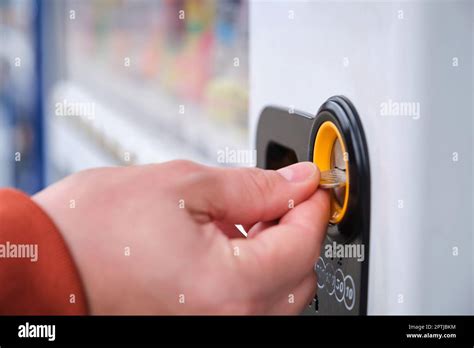 Hand paying 100 yen to get a drink in a japanese vending machine ...