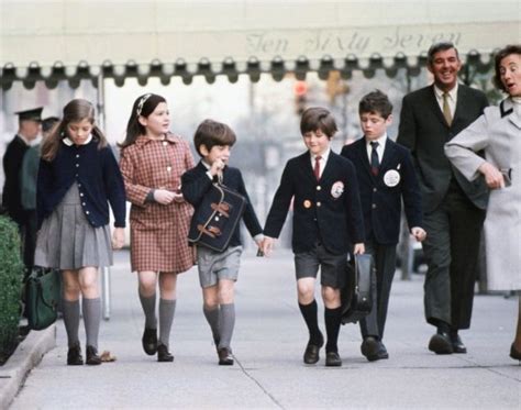 Dressed in school uniforms, Caroline Kennedy (l.) and her little brother JFK Jr. return home ...