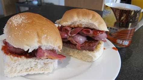 The breakfast of champions. Square Sausage and bacon with red sauce on a Scottish morning roll ...