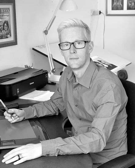 a black and white photo of a man sitting at his desk