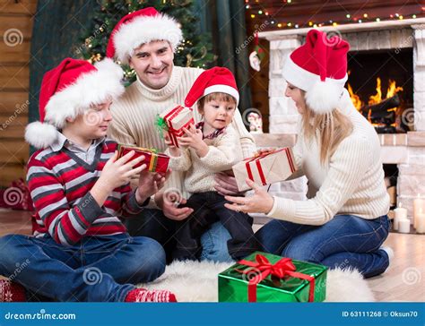 Family Exchanging Gifts In Front Of Christmas Tree Stock Photo - Image: 63111268