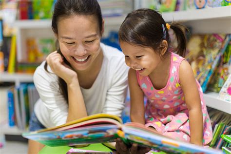 Parent and child reading books together in the library. - CERIC