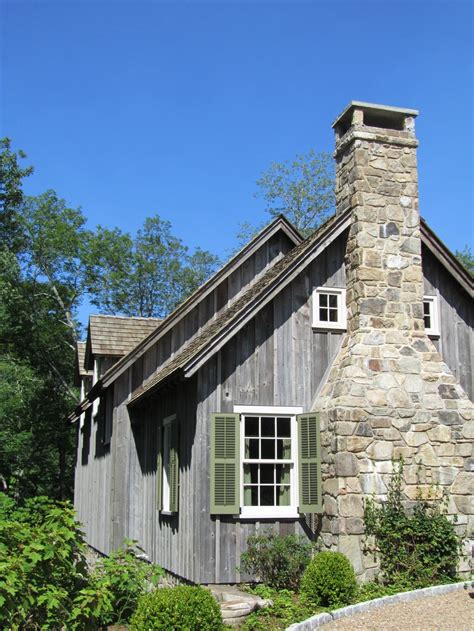 an old stone house with green shutters on the windows and a chimney in ...