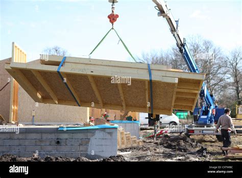 Crane lifting side of house Stock Photo - Alamy