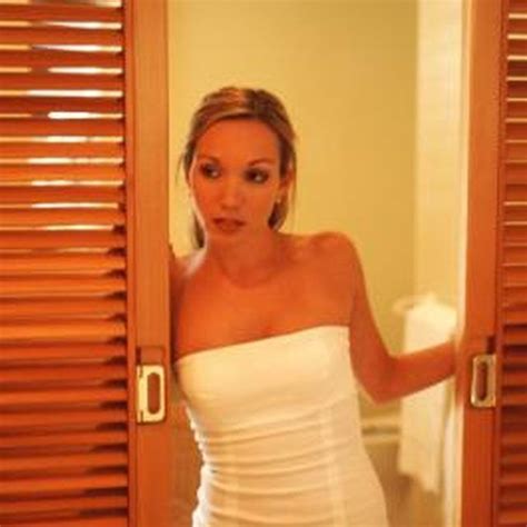 a woman in a white dress looking into a mirror