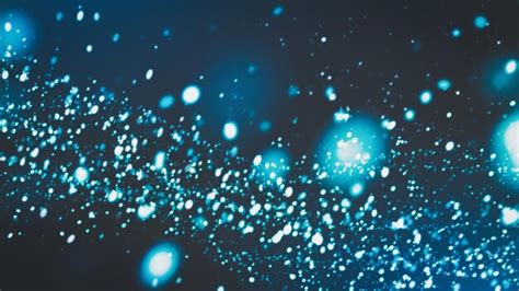 Premium Photo | Blue white glowing dust particles flow on dark background blurred tech webpage ...