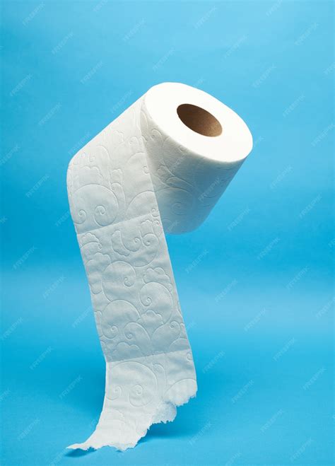 Premium Photo | Torn off white toilet paper roll on minimalistic blue ...