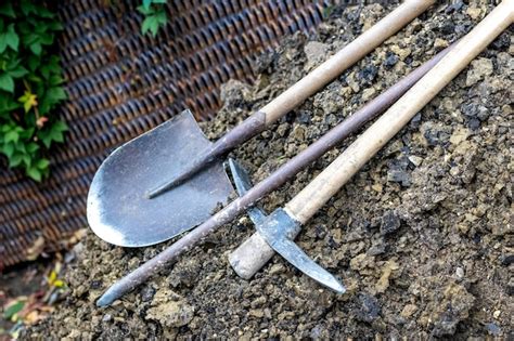 Premium Photo | Shovel, pickaxe and scrap on a pile of earth. trench digging tools