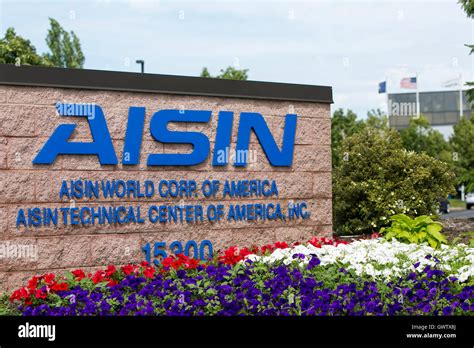 A logo sign outside of a facility occupied by Aisin Seiki Co., Ltd., in ...