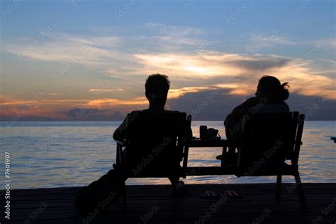 Couple in silhouette sharing sunset over ocean Stock Photo | Adobe Stock