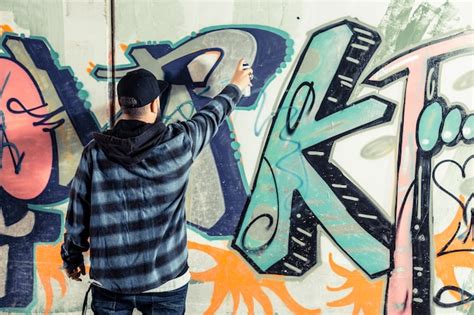 Free Photo | Rear view of a man making graffiti on wall