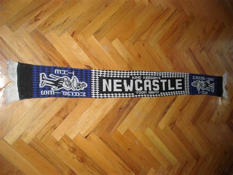 a scarf that says newcastle on it is laying on the floor next to a ...