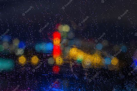 Premium Photo | Raindrops on window at night with bokeh lights ...