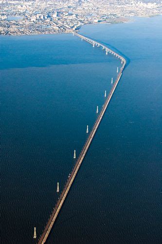 an aerial view of a long bridge spanning the width of a large body of water