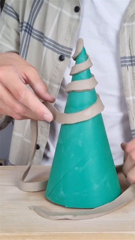 a person is making a paper cone christmas tree